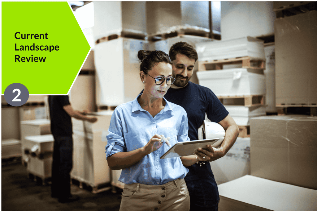 Two people in a warehouse looking at a tablet