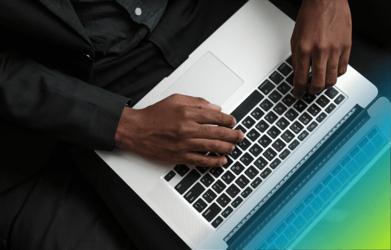 Close-up of a man's hands typing on a laptop keyboard, wearing black business wear,