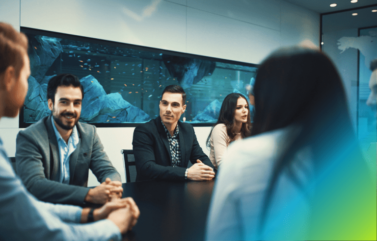 Group of professionals sitting at a black long table having a work meeting.