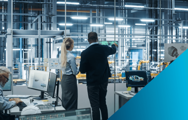 Two management professionals stand in a digital design office overseeing a factory floor. The background features industrial machinery, while the foreground has monitors displaying 3D computer-aided design (CAD) models and digital manufacturing data.